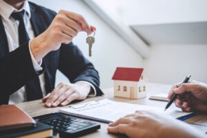 real estate agent giving house keys to client after signing agreement