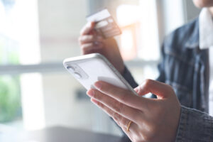 detailed view of person paying on phone using credit card