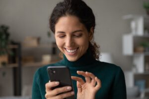 smiling millennial Latina lady touching laptop screen
