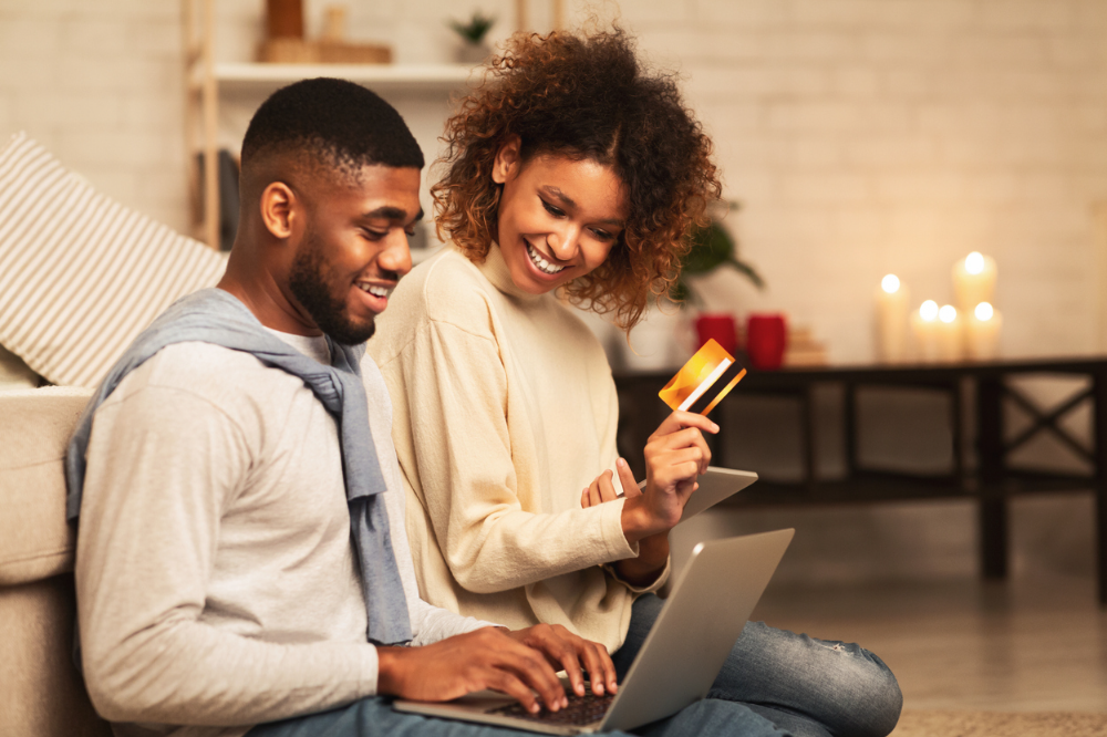 A couple with a credit card and laptop