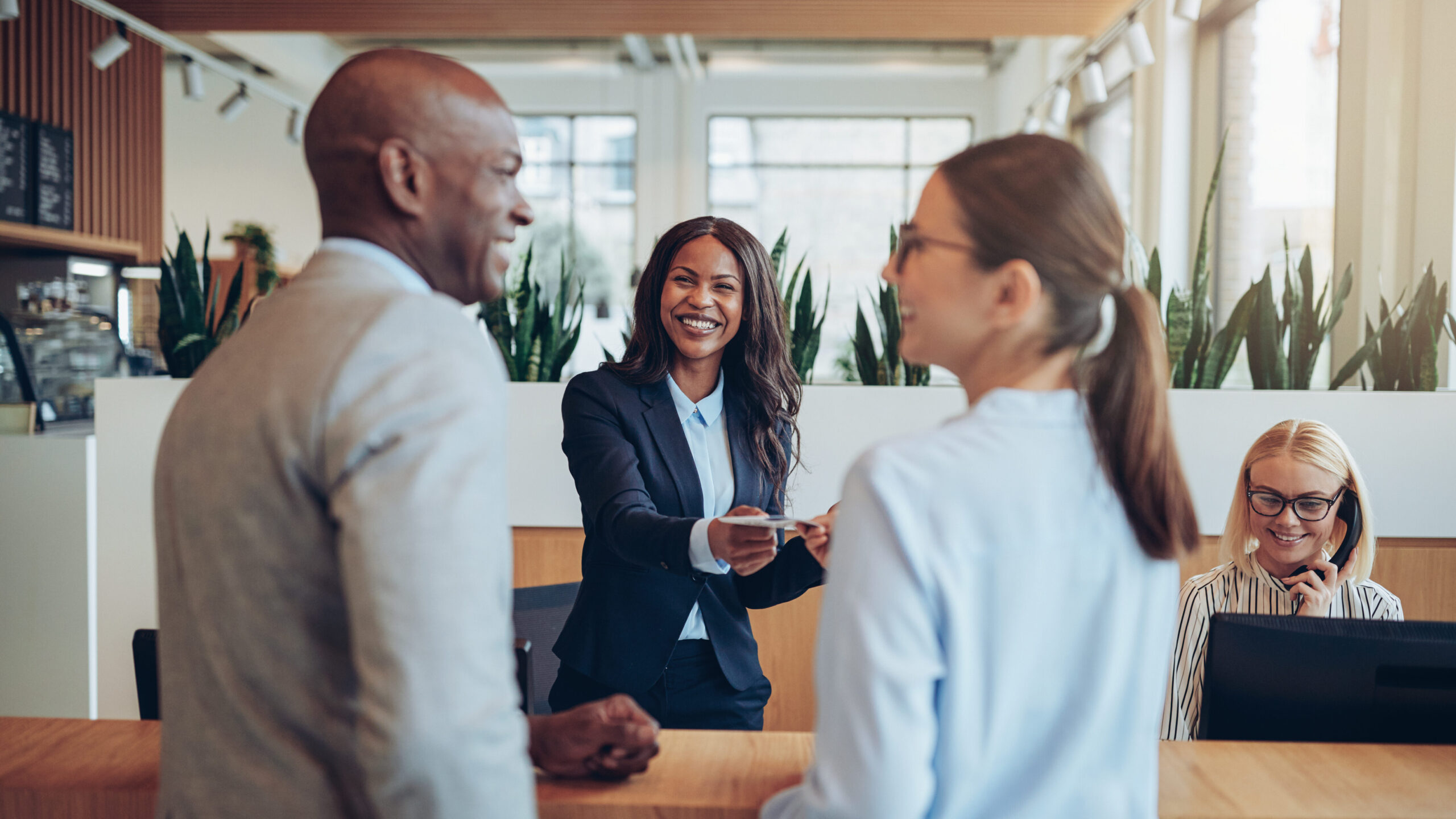 A hotel receptionist talking to a man and woman