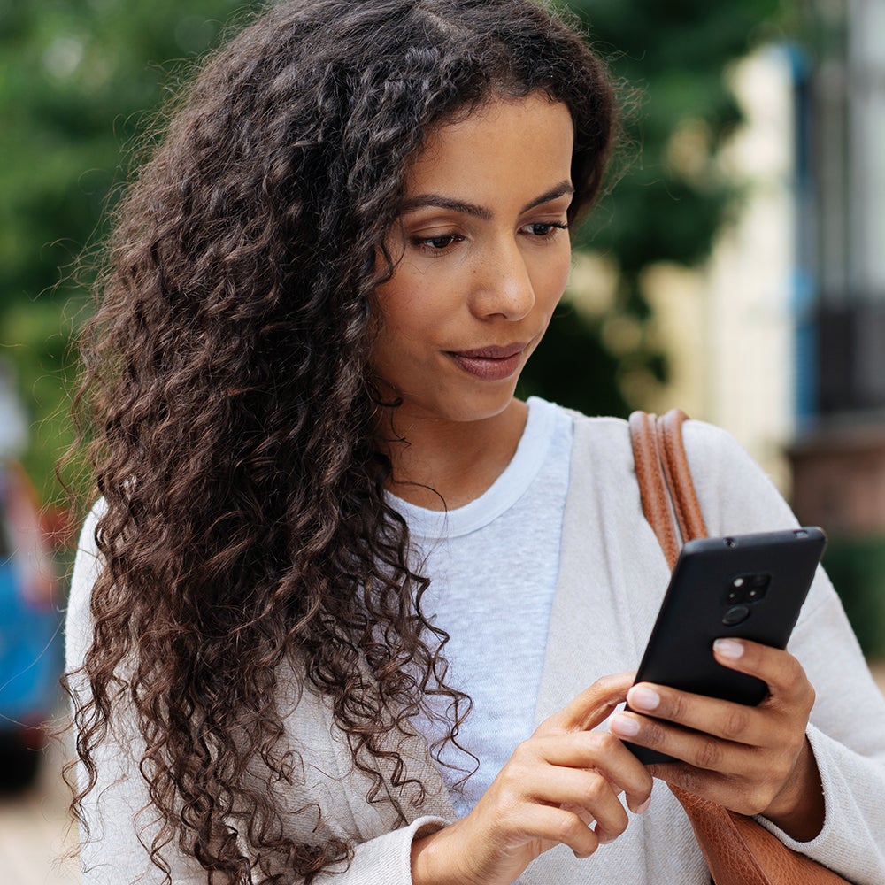 Young woman looking at her phone in consternation