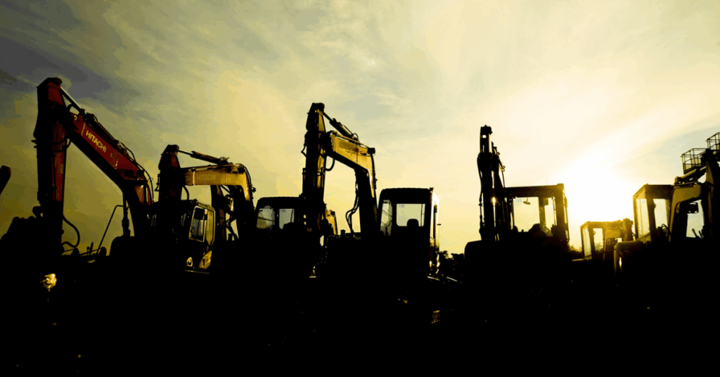 Excavators in front of a yellow sky